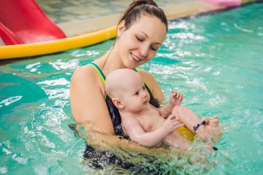 güzel anne kız şirin Bebek Yüzme havuzunda yüzmeyi öğretim. çocuk anne ile suda eğlenmek
