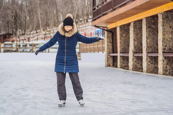 Felice bella ragazza indossa vestiti caldi invernali pattinaggio su ghiaccio — Foto Stock