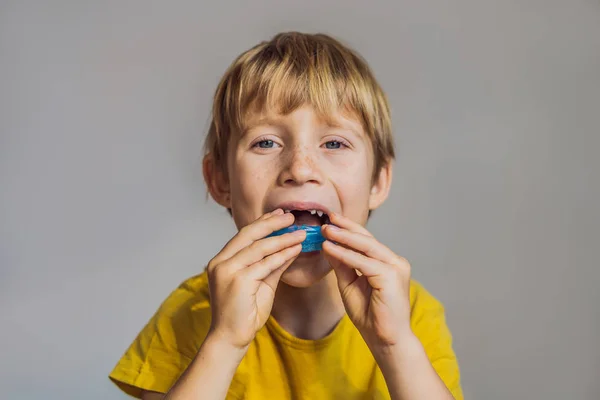 Un niño de seis años muestra un entrenador miofuncional. Ayuda a igualar el crecimiento de los dientes y la mordedura correcta, desarrollar hábito de respiración bucal. Corrige la posición de la lengua —  Fotos de Stock