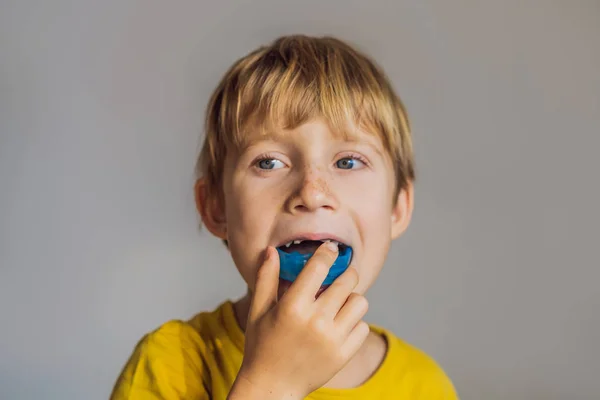 Il bambino di sei anni mostra un allenatore miofunzionale. Aiuta a pareggiare i denti in crescita e correggere il morso, sviluppare l'abitudine respiratoria della bocca. Corregge la posizione della lingua — Foto Stock