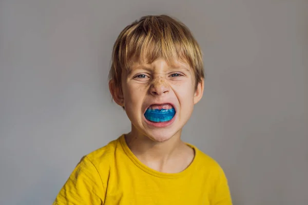 A hatéves fiú rövidlátó edzőt mutat. Segít kiegyenlíteni a növekvő fogak és a helyes harapás, fejlesztése száj légzési szokások. Helyesbíti a nyelv helyzetét — Stock Fotó