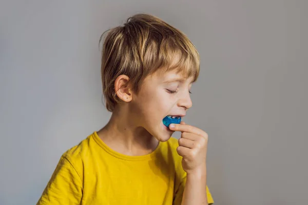 Il bambino di sei anni mostra un allenatore miofunzionale. Aiuta a pareggiare i denti in crescita e correggere il morso, sviluppare l'abitudine respiratoria della bocca. Corregge la posizione della lingua — Foto Stock