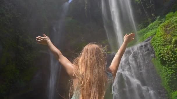 Mladá turistka navštíví největší vodopád na ostrově Bali - vodopád Sekumpul. Zpomalený výstřel. Cestování na Bali koncept — Stock video