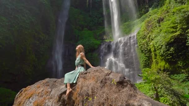 Giovane turista visita la più grande cascata dell'isola di Bali - la cascata di Sekumpul. Colpo di rallentamento. Viaggio a Bali concetto — Video Stock