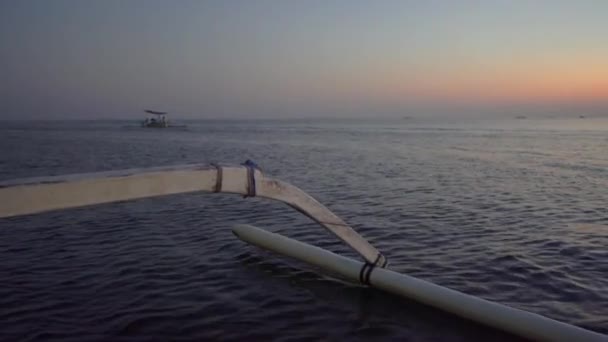 Een ritje in een Aziatische traditionele boot tijdens zonsopgang op weg naar de dolfijnen bezienswaardigheid in de baai van Lovina. — Stockvideo