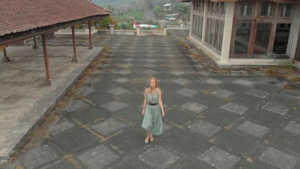 Foto aérea de una turista visitando el hotel abandonado y misterioso en Bedugul. Indonesia, isla de Bali. Concepto de viaje de Bali — Vídeos de Stock