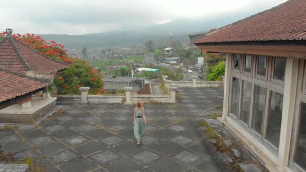 Fotografia aérea de uma turista visitando o hotel abandonado e misterioso em Bedugul. Indonésia, Ilha Bali. Bali Travel Concept — Vídeo de Stock