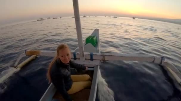 日出时，一家人乘坐亚洲传统的小船。 他们将在巴厘岛北部的洛维纳湾看到海豚。 前往巴厘的旅行概念 — 图库视频影像