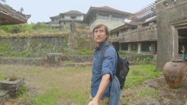 Genç adam Bedugul 'daki terk edilmiş ve gizemli oteli ziyaret ediyor. Endonezya, Bali Adası. Bali Seyahat Konsepti