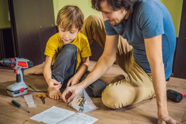 Baba oğul mobilya montajı. Çocuk evde babasına yardım ediyor. Mutlu Aile Konsepti