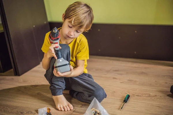 Junge beim Zusammenbau von Möbeln. Junge hilft seinem Vater zu Hause. Glückliches Familienkonzept — Stockfoto