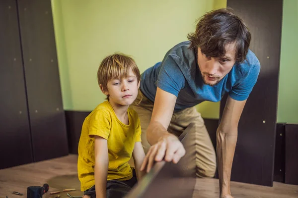 Pai e filho montando móveis. Rapaz a ajudar o pai em casa. Conceito de família feliz — Fotografia de Stock