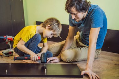 Baba oğul mobilya montajı. Çocuk evde babasına yardım ediyor. Mutlu Aile Konsepti