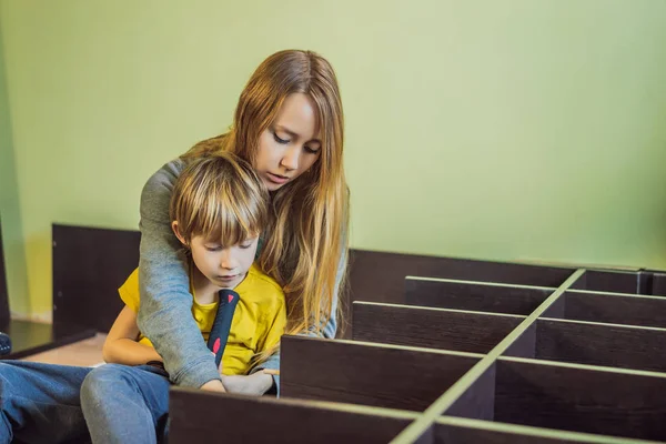 Madre e hijo ensamblando muebles. Un chico ayudando a su madre en casa. Concepto de familia feliz — Foto de Stock