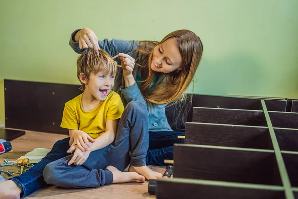 Mãe e filho montando móveis. Rapaz a ajudar a mãe em casa. Conceito de família feliz — Fotografia de Stock