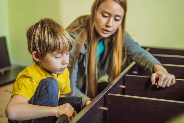 Madre e hijo ensamblando muebles. Un chico ayudando a su madre en casa. Concepto de familia feliz —  Fotos de Stock