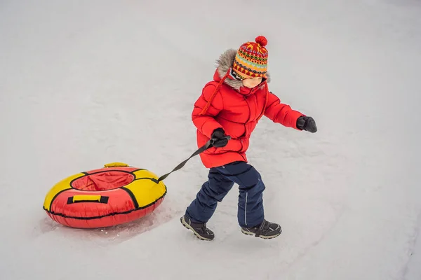 Child having fun on snow tube. Boy is riding a tubing. Winter fun for children — Stock Photo, Image