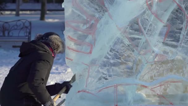 Unbestimmte Person, die eine Eisskulptur herstellt. Konzept für Winteraktivitäten — Stockvideo