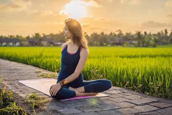 Fiatal nő gyakorlat jóga szabadtéri a rizs mezők a reggel folyamán wellness retreat Bali — Stock Fotó