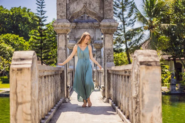 Young woman in dress in Water Palace Soekasada Taman Ujung Ruins on Bali Island in Indonesia. Amazing old architecture. Travel and holidays background — Stock Photo, Image