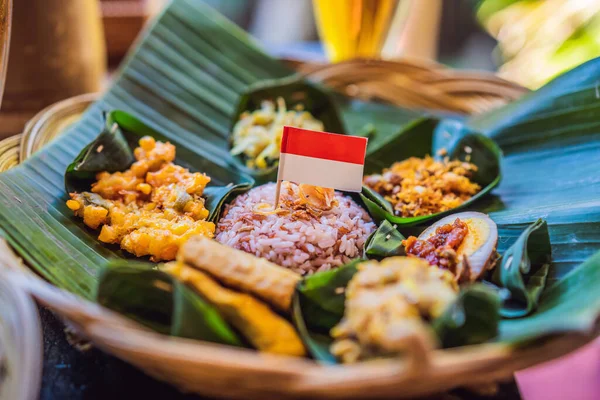 Nasi lemak, Nasi campur, arroz balinês indonésio com batata frita, lilit saciado, tofu frito, ovos picantes cozidos e amendoim — Fotografia de Stock