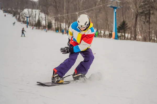 Молодий чоловік стрибає зі сноубордом у горах — стокове фото