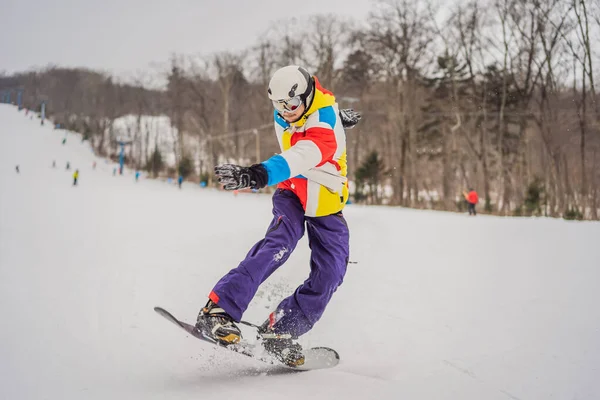 Junger Mann springt mit Snowboard in den Bergen — Stockfoto