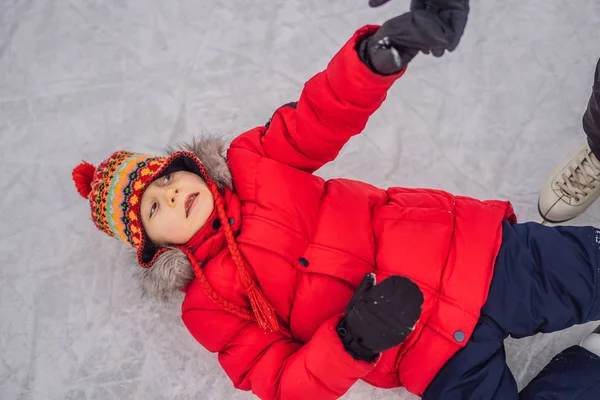 Pojke skridskoåkning föll ner på ishallen — Stockfoto