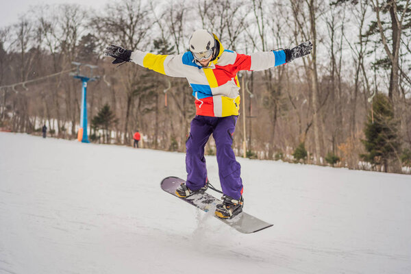 Молодой человек прыгает со сноубордом в горах