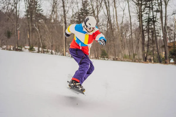 Joven saltando con una tabla de snowboard en las montañas —  Fotos de Stock