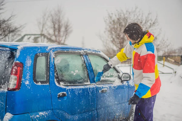 Quitar la nieve del coche con un cepillo —  Fotos de Stock