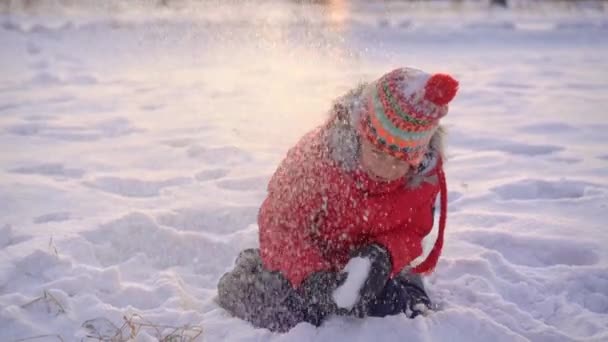 El niño juega bolas de nieve con su madre. Disparo en cámara lenta — Vídeos de Stock