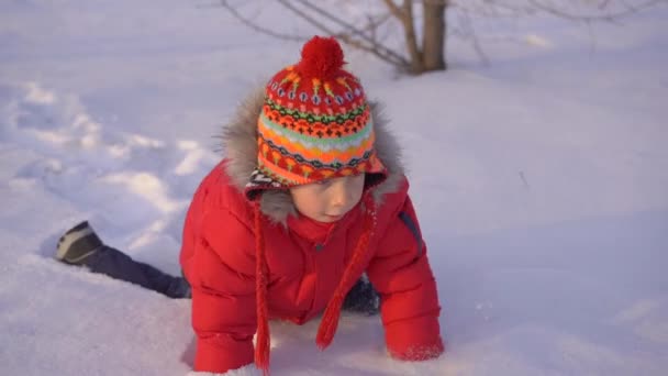 Un niño jugando en la nieve con su madre. Disparo en cámara lenta — Vídeo de stock