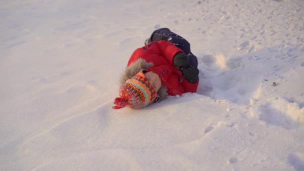 Mały chłopiec bawiący się z matką w śniegu. Strzał zwolniony — Wideo stockowe