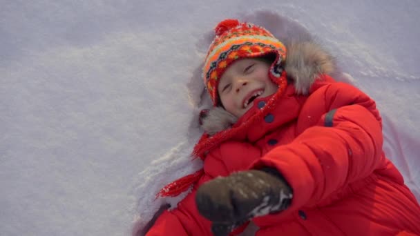 Mały chłopiec bawiący się z matką w śniegu. Strzał zwolniony — Wideo stockowe