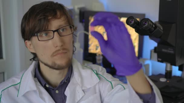 Científico en un laboratorio investiga medicamentos o pastillas — Vídeos de Stock