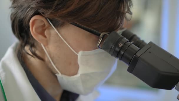 Laboratuvardaki bilim adamları mikroskop kullanır. Yakın çekim. — Stok video