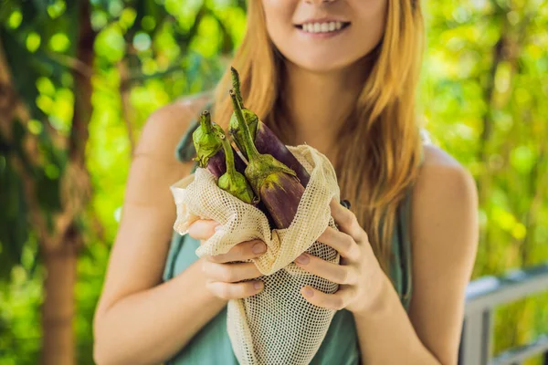 Yeniden kullanılabilir bir çantadaki patlıcan genç bir kadının elinde. Sıfır atık — Stok fotoğraf