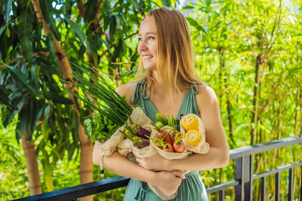 Conjunto de vegetais frescos em uma bolsa reutilizável nas mãos de uma jovem. Conceito de resíduo zero — Fotografia de Stock