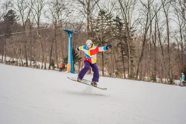 Junger Mann springt mit Snowboard in den Bergen — Stockfoto