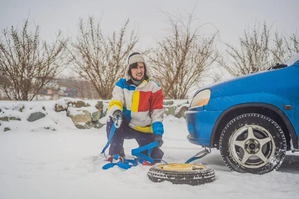 Uomo con ganci di corda di traino vicino all'auto rimorchiata — Foto Stock