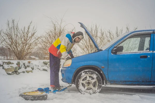 Jóvenes molestos mirando bajo el capó coche roto en la carretera de invierno — Foto de Stock