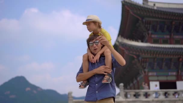 Молодий чоловік з сином відвідують стародавній палац у Сеулі (Південна Корея). Подорож до Кореї. Повільний постріл. — стокове відео