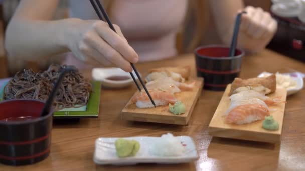 Eine junge Frau in einem japanischen Restaurant isst Sushi. Reise nach Japan — Stockvideo