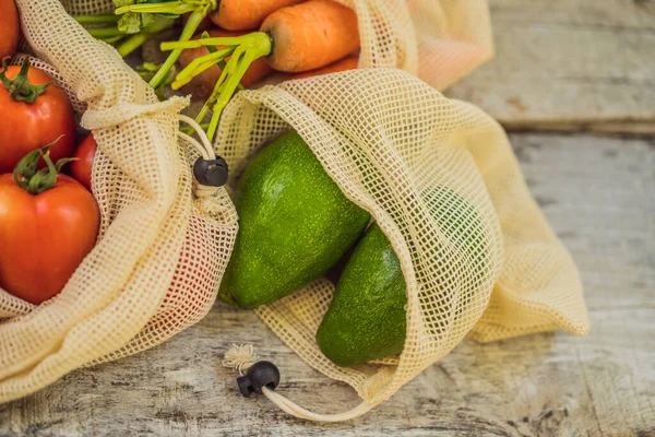 Different vegetables in reusable bags on wooden background. Zero waste concept — Stock Photo, Image