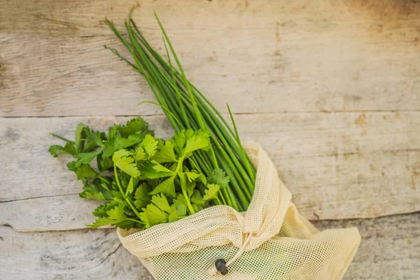 Verse greens in een herbruikbare zak op een stijlvol houten keukenoppervlak. Nul afvalconcept — Stockfoto