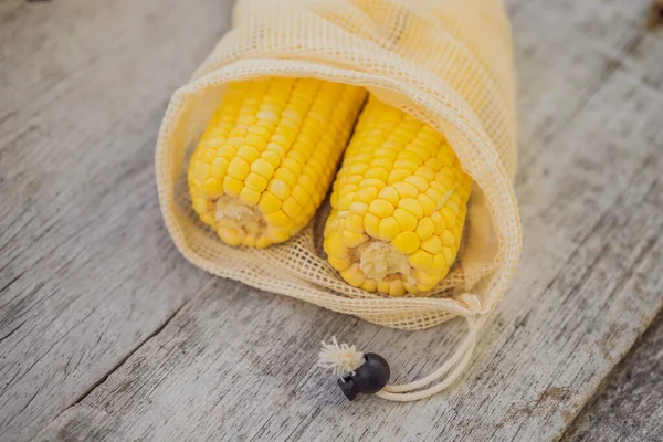 Maïs in een herbruikbare zak op een stijlvol houten keukenoppervlak. Nul afvalconcept — Stockfoto