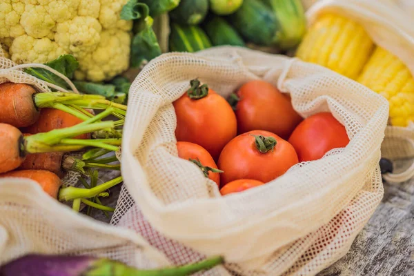 Verschillende groenten in herbruikbare zakken op houten ondergrond. Nul afvalconcept — Stockfoto