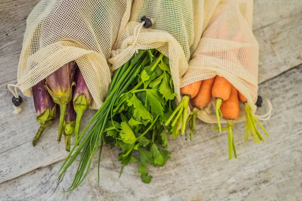 Verschillende groenten in herbruikbare zakken op houten ondergrond. Nul afvalconcept — Stockfoto