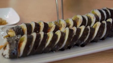 Kore restoranındaki genç adam geleneksel Kore kimpab 'ı yiyor.